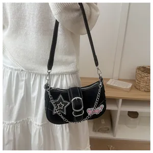 Detailed view of a black Y2K style baguette bag featuring star patch and metal chain