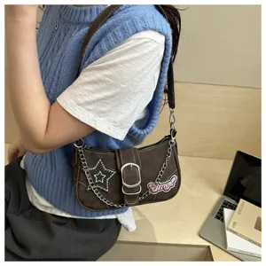 Detailed shot of Y2K style underarm bag featuring star patch and silver chain accessory