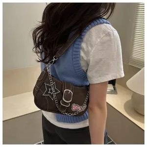 Detailed view of a trendy brown Y2K underarm bag featuring star embroidery and metal chain