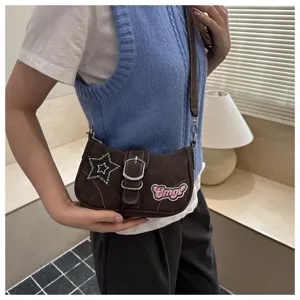 Detailed view of brown Y2K baguette bag with star and Omg! patches on shoulder.