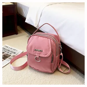 Piccola borsa a tracolla in nylon rosa in un'accogliente ambientazione interna