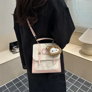 Dettaglio borsa a tracolla chic con motivo marmo rosa e ciondolo gatto in peluche
