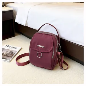 Vista dettagliata della borsa a tracolla in nylon bordeaux con anello in metallo