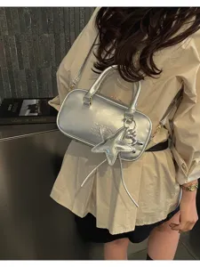 Detailed view of silver metallic Boston handbag with star charm and crossbody strap