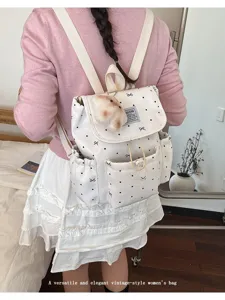 White bow polka dot backpack with drawstring closure shown on model back for college style