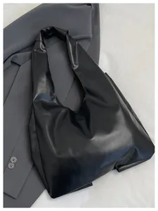 Grand sac fourre-tout hobo noir en similicuir sur fond de tissu gris