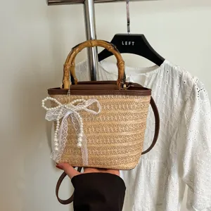 Modische Strohbeuteltasche für den Sommer mit Bambusgriff und Perlenspitzenbogen