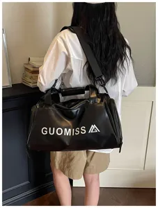 Black waterproof travel duffel bag with shoulder strap, ideal for fitness and gym use.