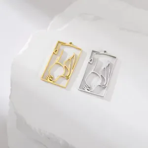 Macro view of minimalist gold and silver stainless steel girl silhouette pendants