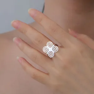 Close-up detail of an African ancient symbol ring in stainless steel worn on a model's hand.