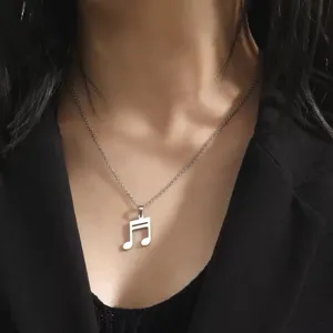 Detailed view of a silver 304 stainless steel musical note pendant necklace on a model.