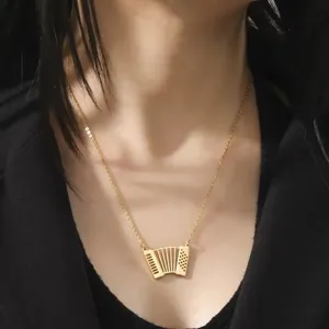 Detailed view of the gold-plated stainless steel accordion pendant on a fine chain