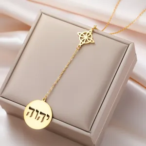 Macro detail of gold stainless steel necklace with Witch's Knot and Hebrew pendant