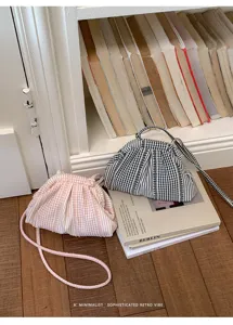 Close-up of minimalist pink and black gingham checkered ruched small bags in a library setting.