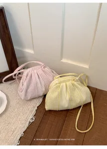 Macro detail of the soft pleated fabric and checkered pattern on these small shoulder bags