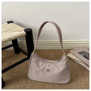 Minimalist purple underarm shoulder bag for women displayed on a natural jute rug