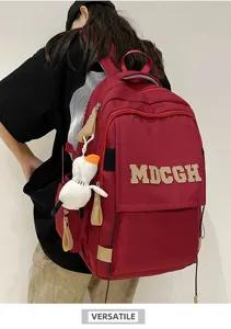 Gros plan de la vue arrière d'un grand sac à dos scolaire rouge avec broderie MDCGH élégante.