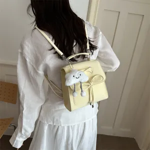 Rückansicht einer Person mit einem blassgelben mattierten Rucksack mit einer Schleife.