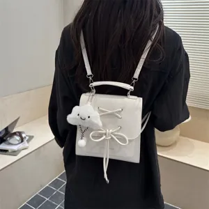 Detailansicht der Rückseite des weißen matten Rucksacks mit Schleife und Wolkenanhänger.