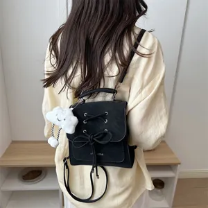 Rückansicht eines schwarzen matten Rucksacks mit Schleifendetail und Wolkenanhänger.