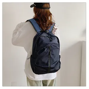 Vista posterior de una persona que lleva una mochila de nylon azul marino de gran capacidad.