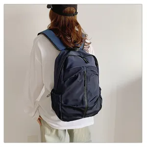 Vista trasera de una persona con una mochila grande azul marino para viajes y escuela