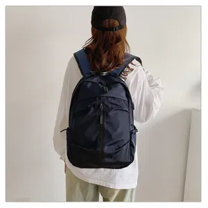 Detalle de una mochila de viaje azul marino de gran capacidad en la espalda