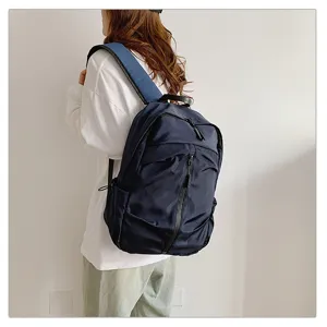 Detalle del bolso de hombro azul marino de gran capacidad usado por una persona