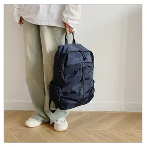 Detalle de una mochila de viaje azul marino grande sostenida por una persona casual