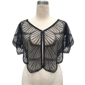 Macro detail of a vintage black mesh capelet with intricate beaded patterns and sequins