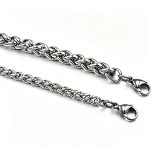 Dettaglio di un bracciale a catena a spiga in acciaio inossidabile con chiusure a moschettone.