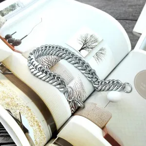 Macro detail of a thick silver-tone stainless steel Cuban link chain for men