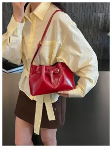 Detailopname van de rode vintage Franse bucket bag met de elegante gouden gesp.