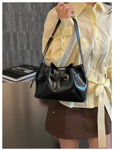 Elegante zwarte schoudertas met vintage gesp, gestyled als een chique onderarmtas
