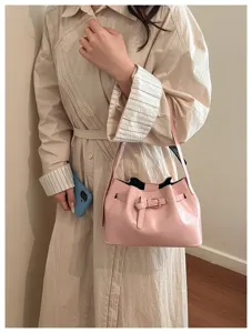 Detailweergave van een roze minimalistische emmertas met gouden gesp en vintage Franse stijl.