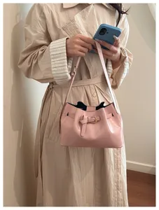 Detail van vintage roze handtas met gesp en geplooid trekkoordontwerp.