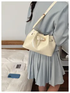 Crèmekleurige vintage Franse okseltas met riemgesp detail gedragen over de schouder