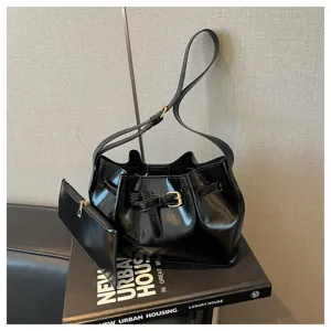 Detailopname van een glanzende zwarte emmertas met gesp op een modern lifestyle boek.