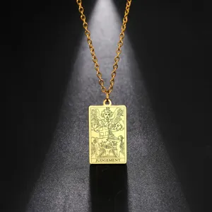 Détail macro d'un collier avec pendentif carte de tarot Judgement en acier doré brillant