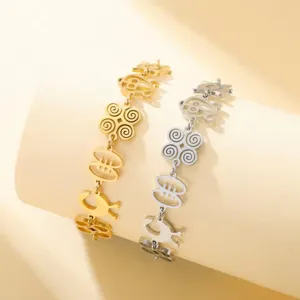 Detailed view of Adinkra symbol bracelets in gold and silver stainless steel finishes