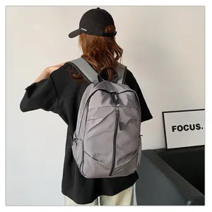 Vista posterior detallada de una mochila informal gris de gran capacidad sobre un modelo