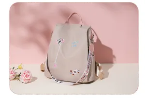 Detailed view of apricot floral embroidered oxford backpack with wide decorative strap