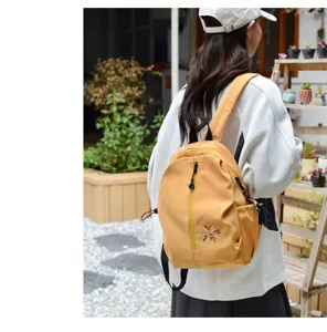 Vista posteriore di uno zaino casual leggero giallo senape con dettaglio ricamo floreale