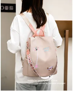 Detailed view of floral embroidery and LOVELY FDIM text on beige Oxford backpack