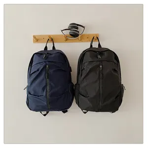 Vista detallada de mochilas de ocio azul marino y negras en un soporte de madera