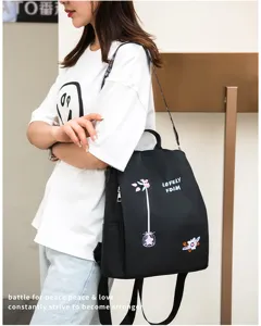 Lifestyle shot of a black oxford backpack featuring delicate floral embroidery detail