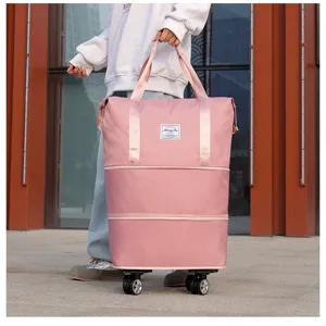 Pink large capacity foldable travel bag with universal wheels shown in an outdoor setting