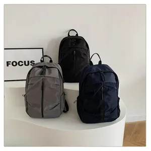 Tres mochilas informales de gran capacidad en negro, gris y azul marino en exhibición