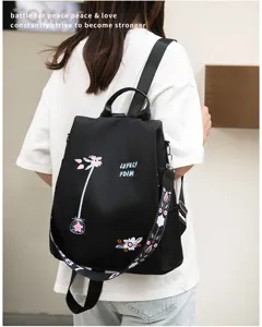 Woman wearing black Oxford backpack with floral embroidery and anti-theft back zipper