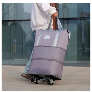 Detailed side view of large purple expandable travel bag with swivel wheels on pavement
